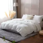 Cama de hotel de lujo con un suave edredón de plumón de pato, ideal para las estaciones frías.