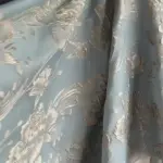صورة مقربة لقماش الجاكار الفاخر، تبرز نمطه المنسوج المعقد وملمسه الفريد
