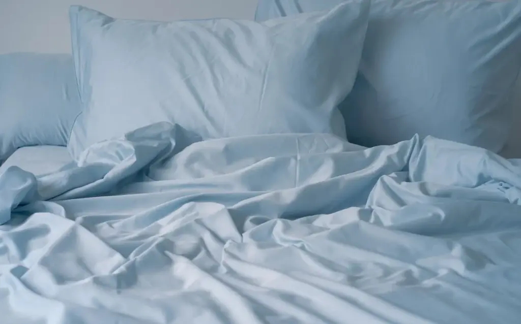 Lightweight down blanket spread smoothly as a layer on a bed, showcasing its sleek profile
