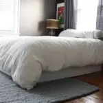 Modernes Schlafzimmerbett mit installiertem Boxspringbezug, der einen ordentlichen Bereich unter dem Bett bietet und einen traditionellen Bettvolant ersetzt